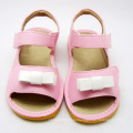 Розовые детские скрипучие сандалии с белым бантом
